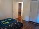 Bedroom and doorway looking into bedroom featuring hardwood floors, white walls and blue rug at 25210 Northlake Dr # 210, Sanford, FL 32773