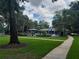 Community pool area with a gazebo, surrounded by green lawns, trees and a sidewalk path at 25210 Northlake Dr # 210, Sanford, FL 32773
