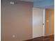 Hallway with wood-look flooring and view of bathroom doorway with closed door, wall with switch plate at 25210 Northlake Dr # 210, Sanford, FL 32773
