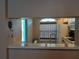 An interior view from the living room looking through the serving hatch to the kitchen and window beyond at 25210 Northlake Dr # 210, Sanford, FL 32773