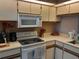 Kitchen showcasing microwave, oven, wooden cabinets and countertops, and wooden organizers at 25210 Northlake Dr # 210, Sanford, FL 32773