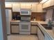 Efficient kitchen featuring white appliances, a range, a microwave, and ample counter space at 25210 Northlake Dr # 210, Sanford, FL 32773