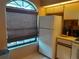 Kitchen featuring a window with blinds next to the refrigerator and adjacent to the range and microwave oven at 25210 Northlake Dr # 210, Sanford, FL 32773