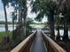 Scenic lake view from the end of a wooden deck, surrounded by tropical trees at 25210 Northlake Dr # 210, Sanford, FL 32773