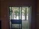 View of outdoor screened-in porch featuring a fan, trees with moss, and sliding glass doors to interior at 25210 Northlake Dr # 210, Sanford, FL 32773