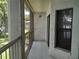 Screened porch with railing featuring partial view of landscaping, exterior building, window and wall lighting at 25210 Northlake Dr # 210, Sanford, FL 32773