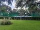 Manicured lawn overlooking a community tennis court, surrounded by lush greenery at 25210 Northlake Dr # 210, Sanford, FL 32773