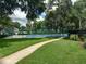 Manicured lawn with a sidewalk path overlooking a community tennis court at 25210 Northlake Dr # 210, Sanford, FL 32773