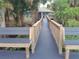 Scenic walkway flanked by benches, leading to a charming house surrounded by lush greenery at 25210 Northlake Dr # 210, Sanford, FL 32773