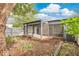 View of screened lanai, looking onto landscaped backyard with natural growth and a wood fence in the background at 2541 Leeward Way, Winter Park, FL 32792