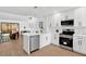Modern kitchen with stainless steel appliances, white cabinets, and an open layout to living area at 2541 Leeward Way, Winter Park, FL 32792
