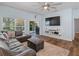 Open-concept living room with sliding glass door access to the patio and a mounted television at 2604 Bullion Loop, Sanford, FL 32771