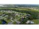 Birds eye view of a home situated in a residential neighborhood with plenty of surrounding tree coverage at 2707 Carmel Ct, Kissimmee, FL 34746