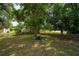 Spacious fenced backyard featuring mature trees, a swing, and a storage shed for outdoor enjoyment at 2707 Carmel Ct, Kissimmee, FL 34746