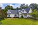 Charming Cape Cod home featuring a well-manicured lawn, tidy landscaping, and welcoming front porch at 2707 Carmel Ct, Kissimmee, FL 34746