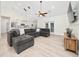 A modern living room with vaulted ceilings, wood flooring, and a sectional couch at 2707 Carmel Ct, Kissimmee, FL 34746