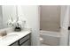 Clean bathroom featuring a single vanity, decorative mirror, and a tiled bathtub/shower combination at 2927 Believe In Yourself Ct, Clermont, FL 34714
