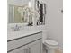 Well-lit bathroom features a modern vanity, elegant faucet, sleek countertop, and an eye-catching piece of artwork at 2927 Believe In Yourself Ct, Clermont, FL 34714