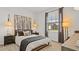 Cozy bedroom showcases a well-dressed bed, complementary lamps, side tables, and a window with neighborhood views at 2927 Believe In Yourself Ct, Clermont, FL 34714