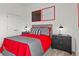 Cozy bedroom features a red bedspread, gray accents, two side tables, and modern decor at 2927 Believe In Yourself Ct, Clermont, FL 34714