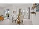 Bright dining area features a modern table, neutral chairs, and sliding doors leading to the outdoor space at 2927 Believe In Yourself Ct, Clermont, FL 34714