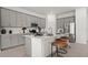 Modern kitchen boasts gray cabinets, stainless steel appliances, quartz countertops, and breakfast bar seating at 2927 Believe In Yourself Ct, Clermont, FL 34714