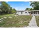 Expansive backyard featuring a charming white home, a lush lawn, and a paved walkway at 330 N Stone St, Deland, FL 32720