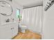 Bright bathroom featuring a white vanity with a round mirror and a shower with a white curtain at 330 N Stone St, Deland, FL 32720