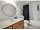 Bathroom featuring a wood vanity with a large round mirror and tub/shower combo at 345 Goldstone Pl, Lake Mary, FL 32746