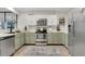 A kitchen showcasing stainless steel appliances, modern white and green cabinetry, and light countertops at 345 Goldstone Pl, Lake Mary, FL 32746