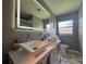 The bathroom showcases double sinks with modern fixtures and a large, lit mirror for a bright ambiance at 3702 Mirror Lake Dr, Apopka, FL 32703