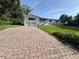 Inviting property featuring a brick driveway leading up to a beautiful home with a well-maintained lawn and welcoming facade at 3702 Mirror Lake Dr, Apopka, FL 32703