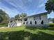 Side angle of a charming two-story home with white siding, well-manicured lawn, and attached two-car garage at 3702 Mirror Lake Dr, Apopka, FL 32703