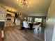 Open-concept living room and kitchen with modern lighting and dining area with white chairs and a table at 3702 Mirror Lake Dr, Apopka, FL 32703