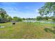 Large, fenced backyard overlooking a serene lake, complete with lush greenery and ample space at 3824 Johnson St, Orlando, FL 32805