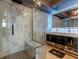 This luxurious bathroom features marble walls, a glass-enclosed shower with a bench, and a modern double vanity at 400 E Colonial Dr # 1103, Orlando, FL 32803