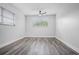 Bright bedroom with gray wood-look flooring, a ceiling fan, and a large window providing ample natural light at 418 Tulane Dr, Altamonte Springs, FL 32714