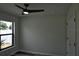 Bedroom with wood-look flooring, modern ceiling fan and lighting, and a side yard view at 508 Bennett St, Auburndale, FL 33823