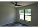 This bedroom offers wood-look flooring, a modern ceiling fan, and a large window overlooking the backyard at 508 Bennett St, Auburndale, FL 33823
