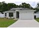 Charming single-story home with a gray exterior, well-manicured lawn, and a two-car garage at 508 Bennett St, Auburndale, FL 33823