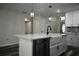 Kitchen island features a sink and dishwasher with modern light fixtures at 508 Bennett St, Auburndale, FL 33823