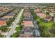 Aerial view of a residential street, showing the roof of a home and neighborhood pools at 5255 Wildwood Way, Davenport, FL 33837