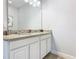 Bathroom featuring double granite vanity, sleek white cabinetry offering ample storage, and contemporary fixtures at 5255 Wildwood Way, Davenport, FL 33837