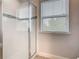 Tiled walk-in shower with sliding glass doors and window at 5255 Wildwood Way, Davenport, FL 33837