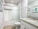 Well-lit bathroom featuring shower with tile accents and a vanity with storage at 5255 Wildwood Way, Davenport, FL 33837