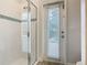 Bathroom with a glass-enclosed shower and an adjacent exterior door with built in blinds for privacy at 5255 Wildwood Way, Davenport, FL 33837