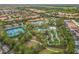 Aerial view of the community pool and amenity center, surrounded by lush landscaping and mature trees at 5255 Wildwood Way, Davenport, FL 33837