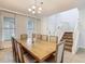 Bright dining room features a large wooden table, elegant chandelier, and a staircase to the upper level at 5255 Wildwood Way, Davenport, FL 33837