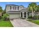 Charming two-story home with a two-car garage, landscaped yard, and arched entryway at 5255 Wildwood Way, Davenport, FL 33837