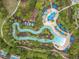 Aerial view of a relaxing lazy river with lush landscaping and sunbathing areas, perfect for leisurely enjoyment at 5255 Wildwood Way, Davenport, FL 33837
